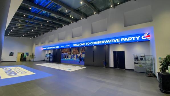 An empty conference centre with a big blue sign reading 'Welcome to Conservative Party'