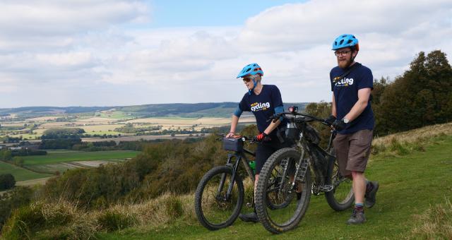 Sam Jones (right, CUK) and Hannah Dobson (Singletrack) walking their bikes towards the Crown on Wye September 30, 2018. The riders were undertaking a recce of Cycling UK's proposed "riders route" of the North Downs Way as part of the 40th anniversary celebrations of the national trail.