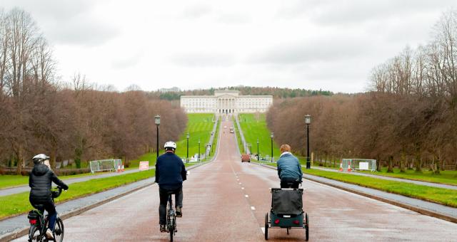Three cyclists on the long road in front of Stormont, Belfast