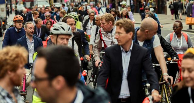 A large group of cyclists in ordinary clothes waiting to start on a mass ride