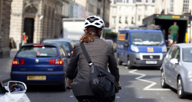woman cyclist commuting amongst traffic 