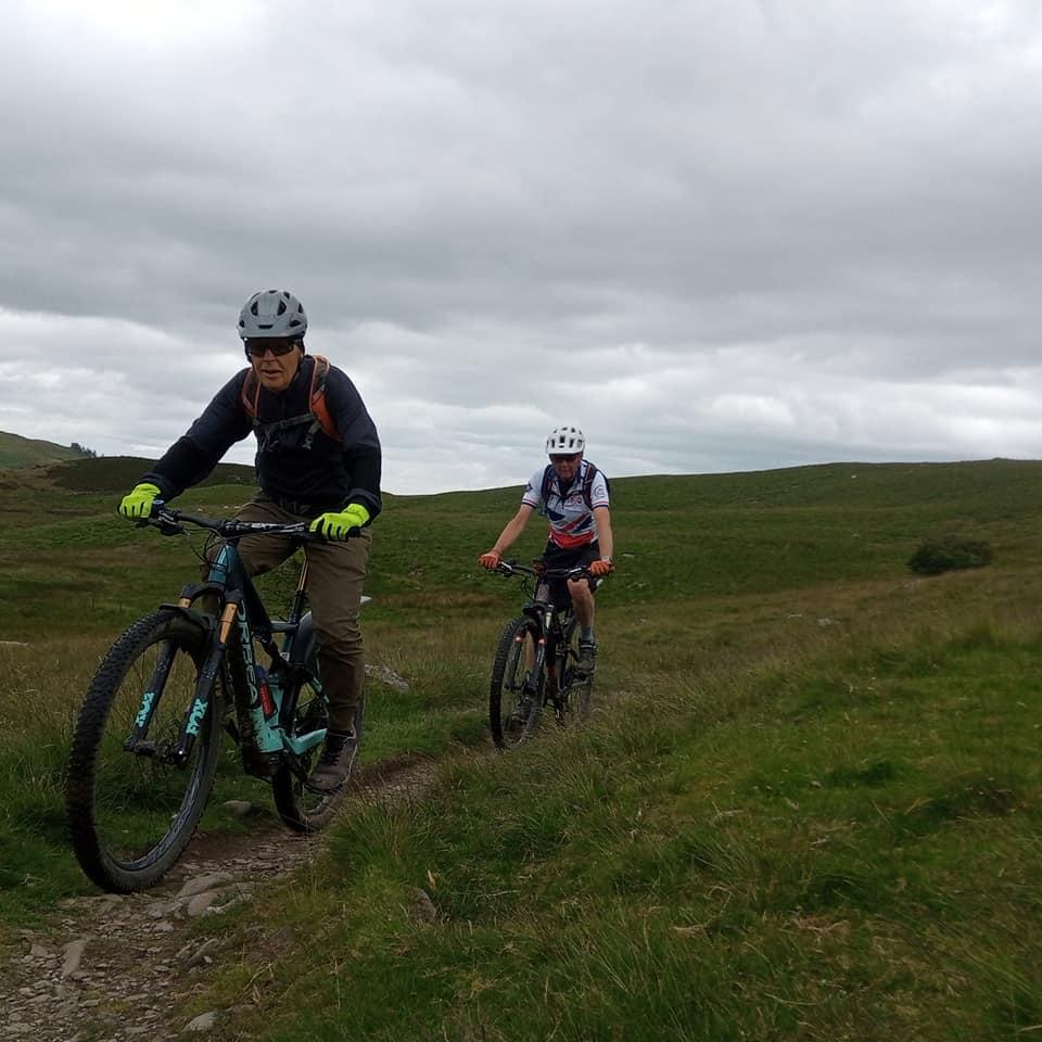 Three people riding up a hill on bikes