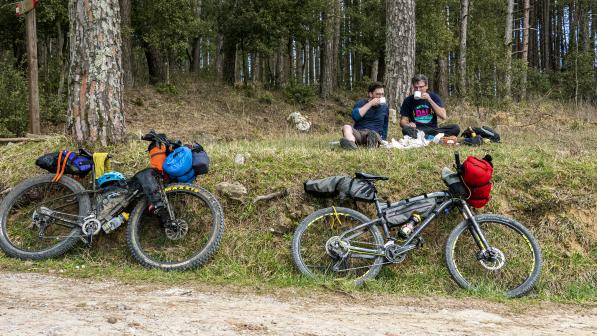 Two cyclists enjoy a break in the Tuscan hills