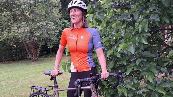 Woman wearing Kalas Cycling UK jersey while standing next to bike outside