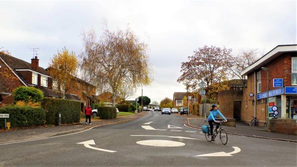 A woman cycling around a roundabout.